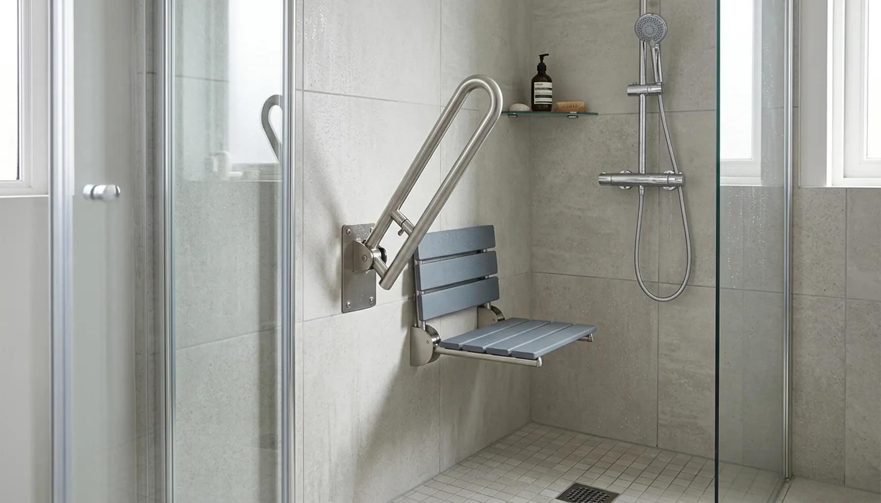 folding grab bar partially folded next to shower seat in modern bathroom shower