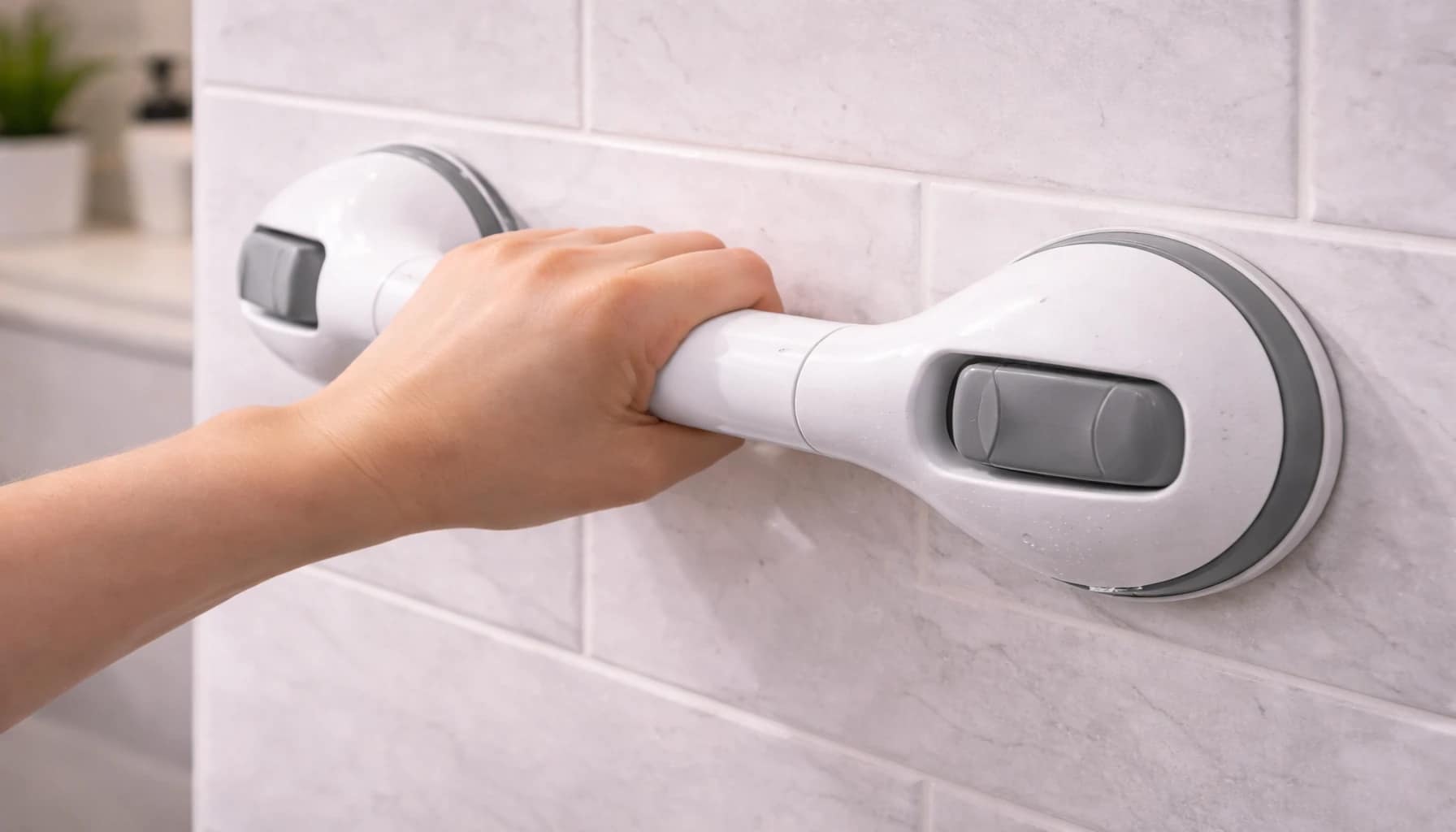are suction grab bars safe for seniors shown by a hand testing a suction grab bar mounted on a bathroom tile wall